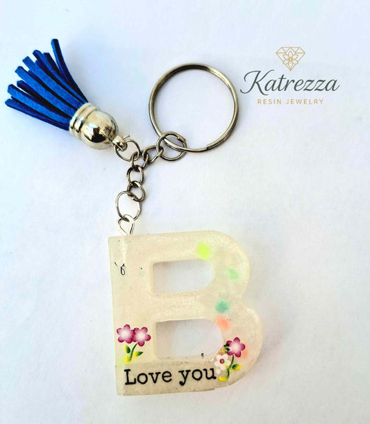 “Glow-in-the-dark resin letter B keychain with blue tassel and Love You floral design.”