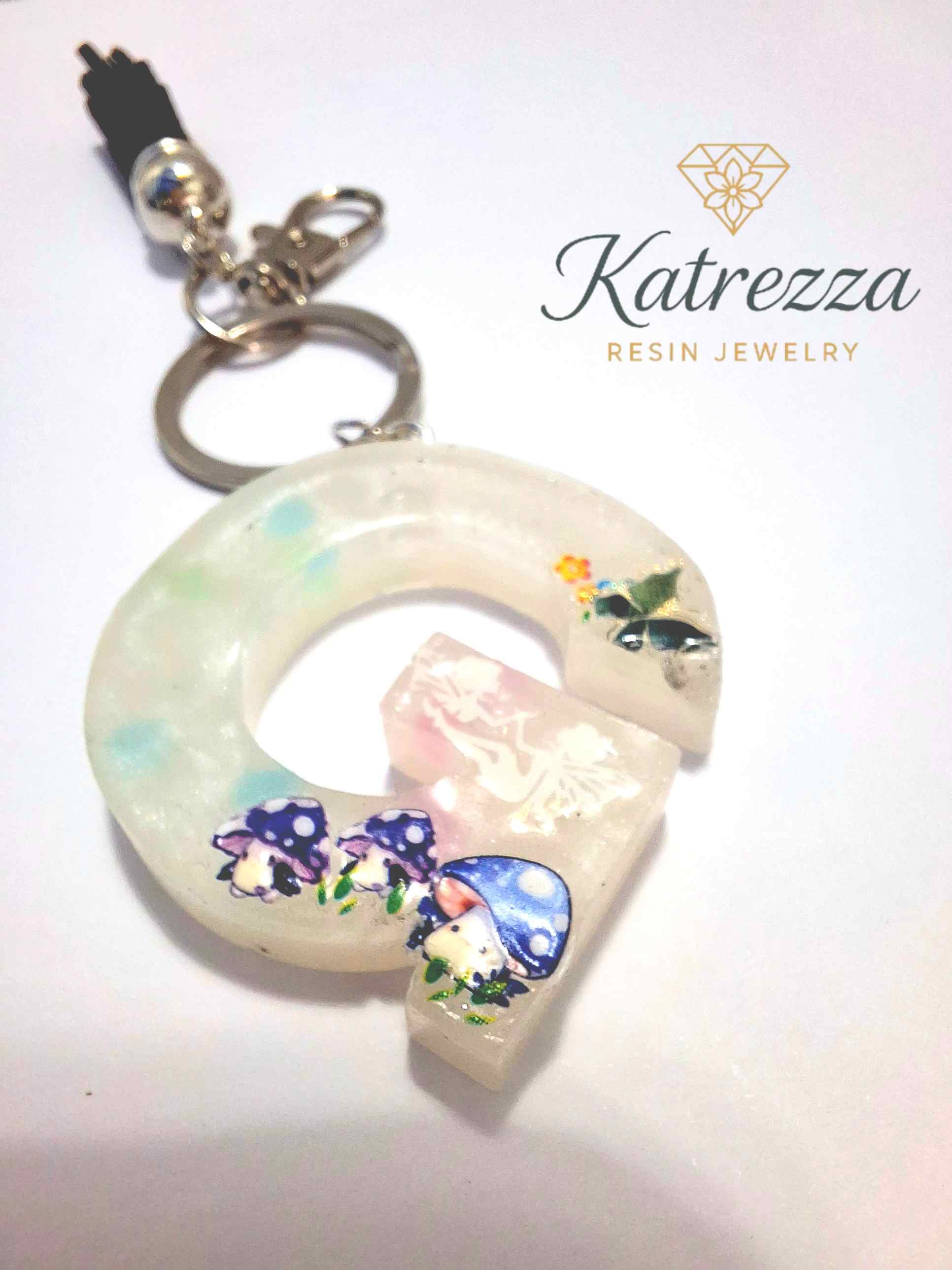 Handmade resin G keychain with fairy silhouette, mushrooms, and butterfly decorati